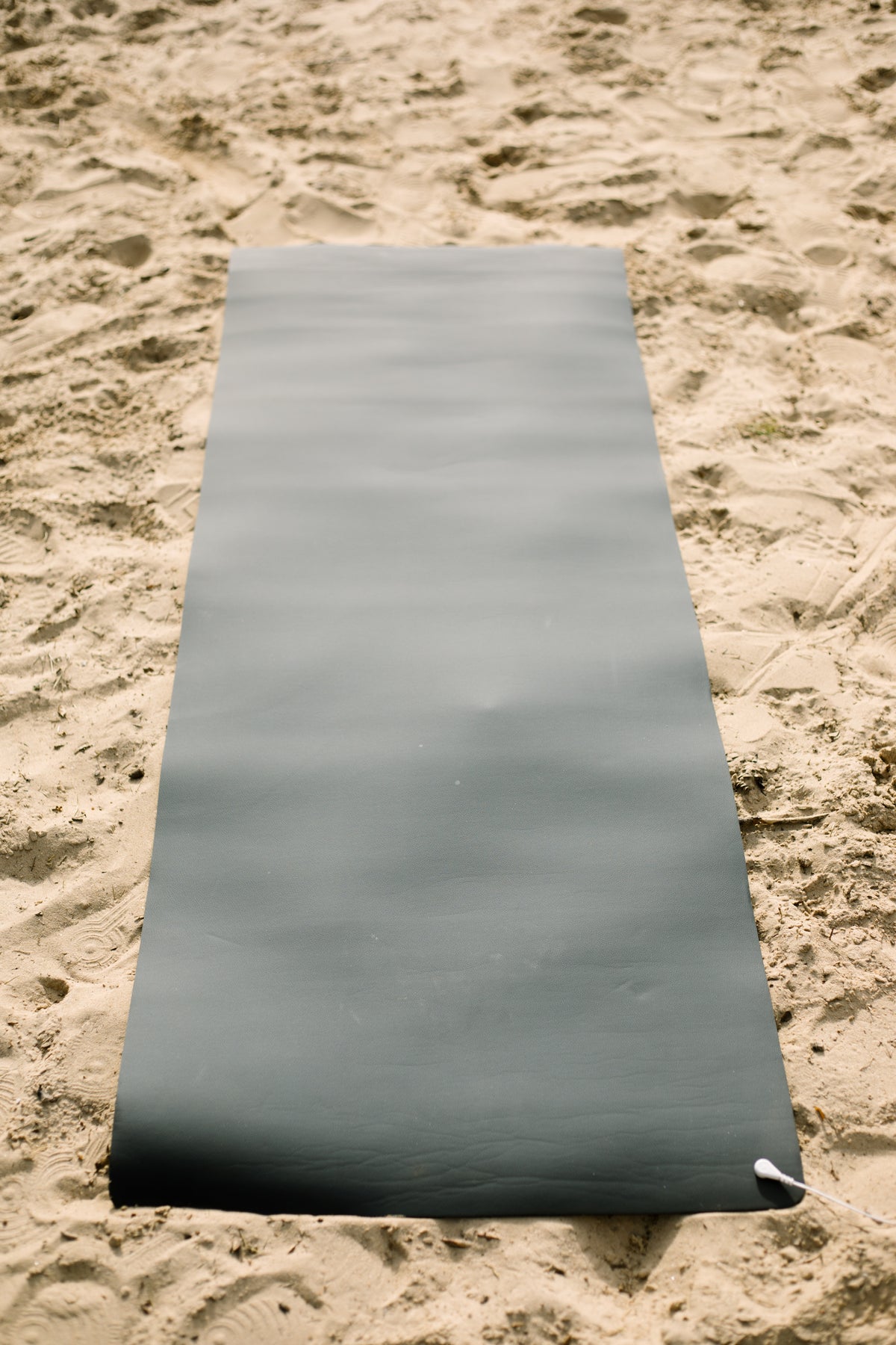 Earthle Erdungs-Yogamatte im Sand ausgerollt