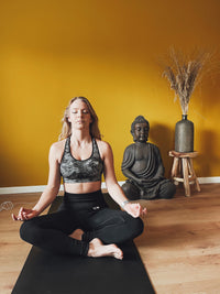 Frau im Schneidersitz meditierend auf der Earthle Erdungs-Yogamatte
